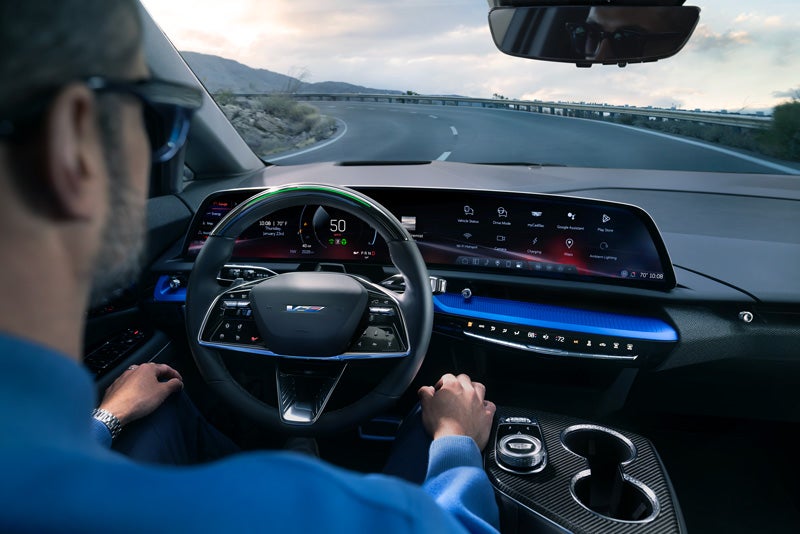 Front View of the 2026 OPTIQ-V Driving Through the Dusk Utilizing its Headlights | Corwin Motors Kalispell Cadillac in Kalispell MT